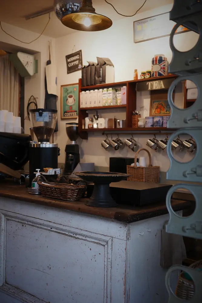 Counter corner with grinder, hanging mugs and vintage posters