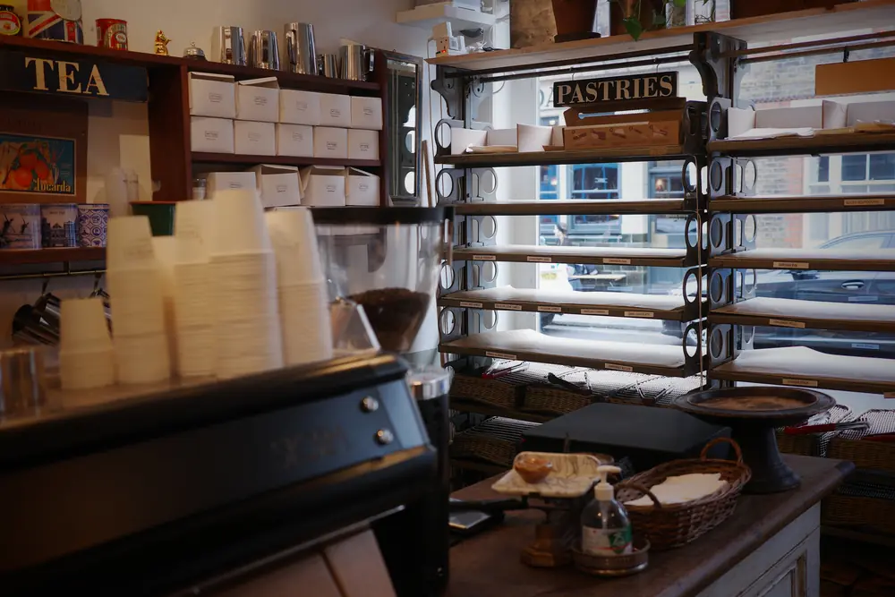 Tea shelves and cups beside the window pastry display