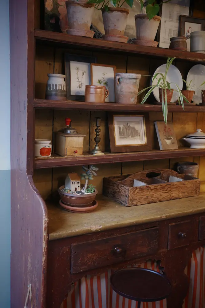 Detail of the dresser shelves with a vintage grinder and prints