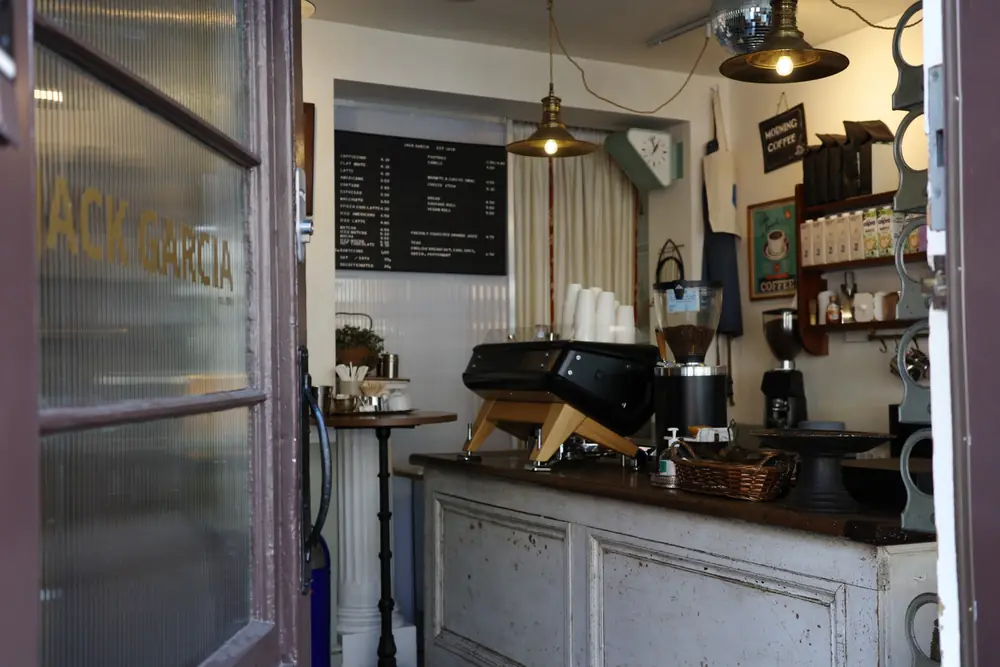 The open front door looking in at the counter under brass pendant lamps